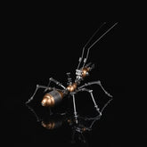 The golden mechanical ant model kit, a steampunk 3D metal puzzle, shown in a side profile on a black reflective surface.