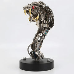 Front view of the mechanical cobra head on a black base, featuring the luminous red eye and detailed metallic scales