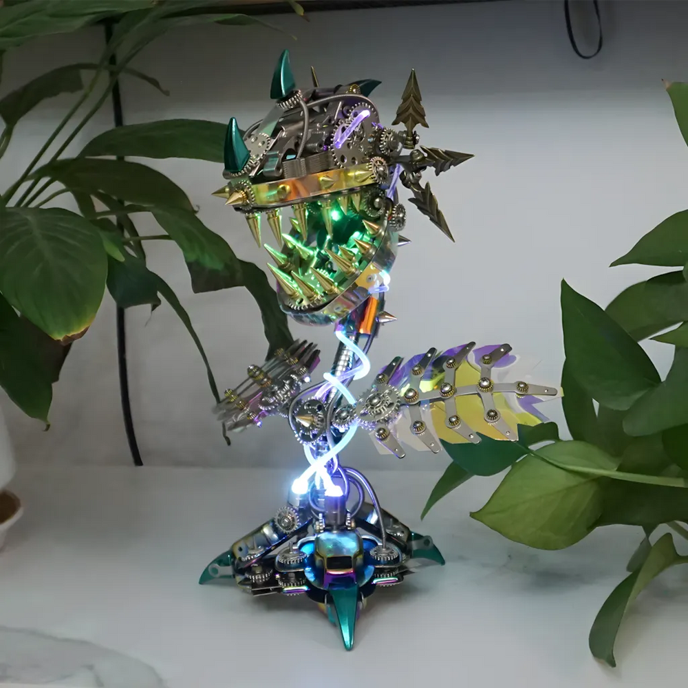 The robot plant model with a green internal glow, displayed on a desk surrounded by real plants, highlighting the unique contrast