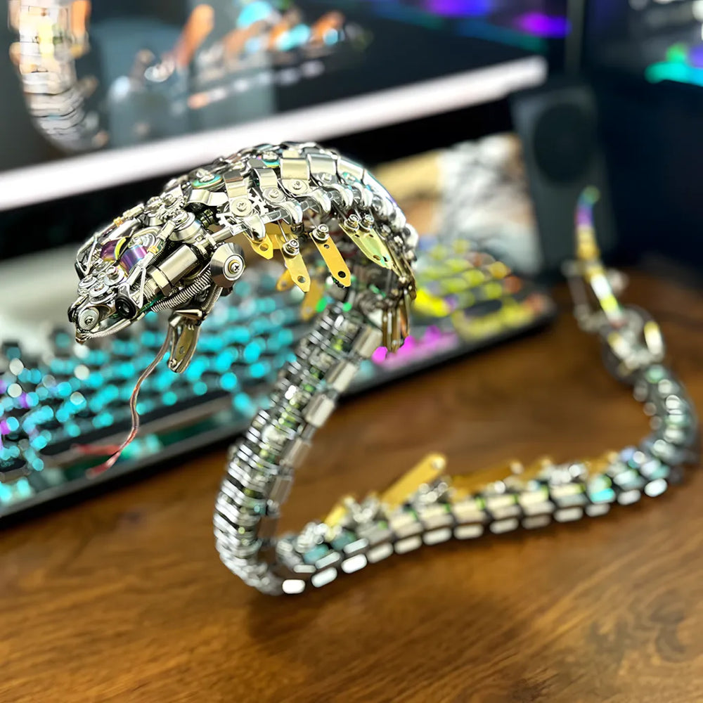 Close-up of the robot snake head in a lifestyle setting, detailing the complex metallic head and articulated neck against a modern keyboard.