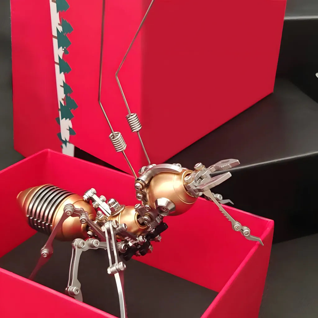 The golden mechanical ant model placed inside a red gift box, emphasizing its suitability as a gift for engineers and hobbyists