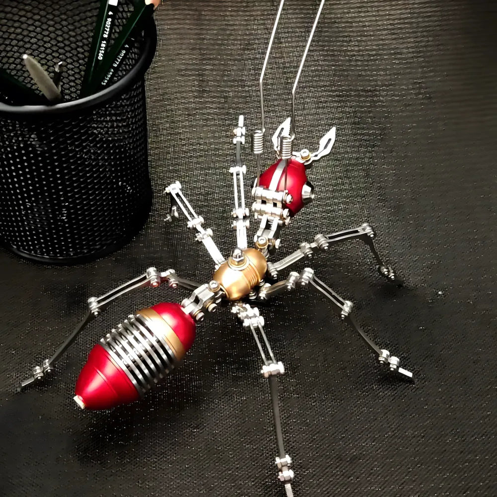 The red and gold variant of the bionic ant model placed on a dark surface next to office supplies, showcasing the color option