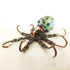 The Mechanical Octopus model with a bright green luminous orb and bronze tentacles, shown on a reflective white background